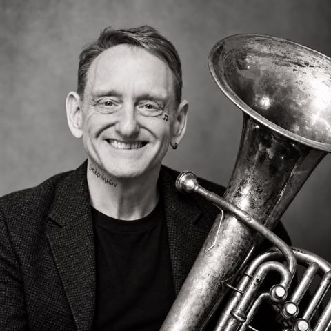 Black-and-white portrait of Larry Herzog Jr. holding a euphonium
